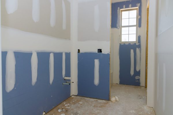 A newly constructed house in the process of being plastered drywall is ready for painting